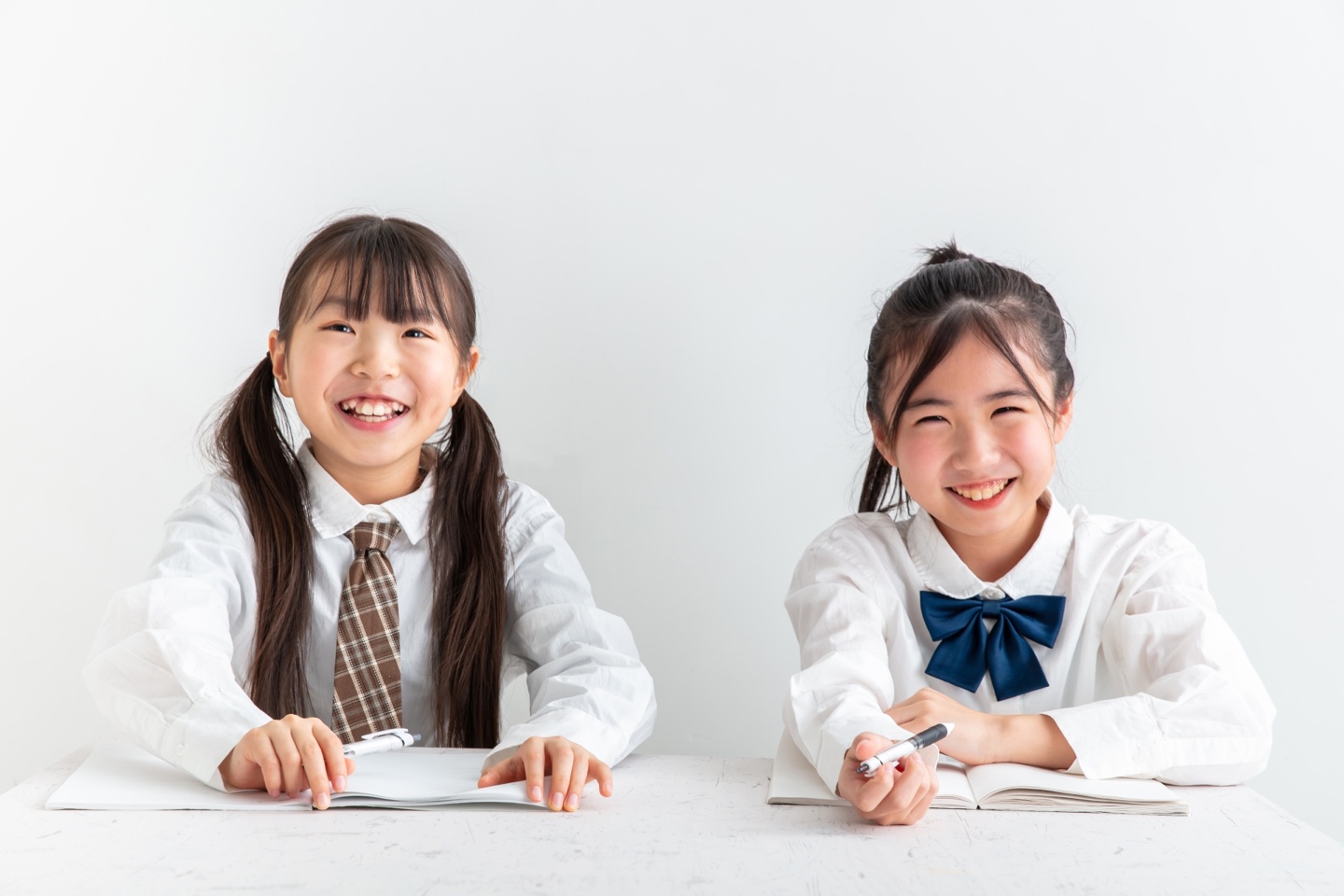 笑顔で机に向かい学習する小学生たちのイメージ