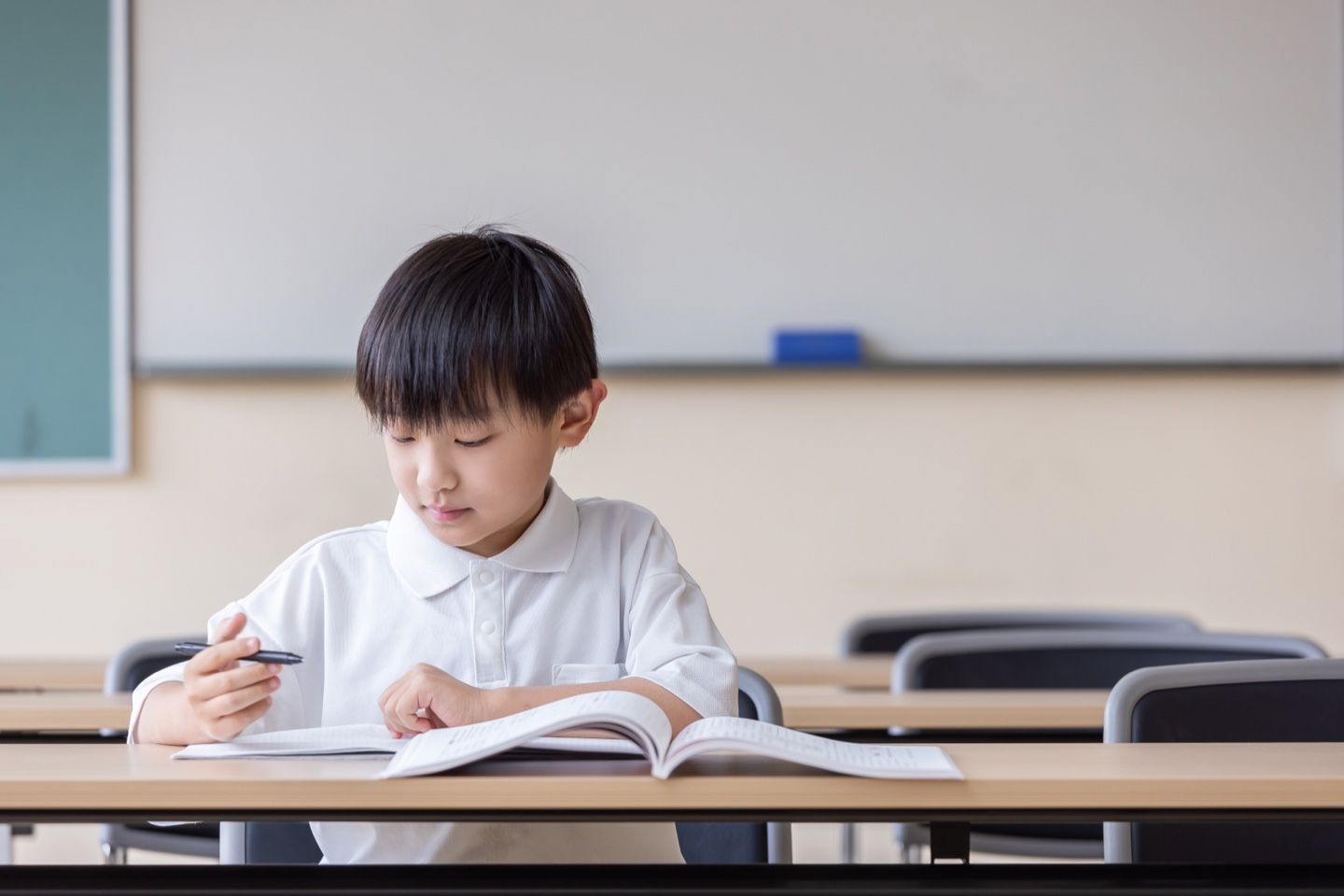 教室で教材を開き、学び方を確かめる小学生のイメージ