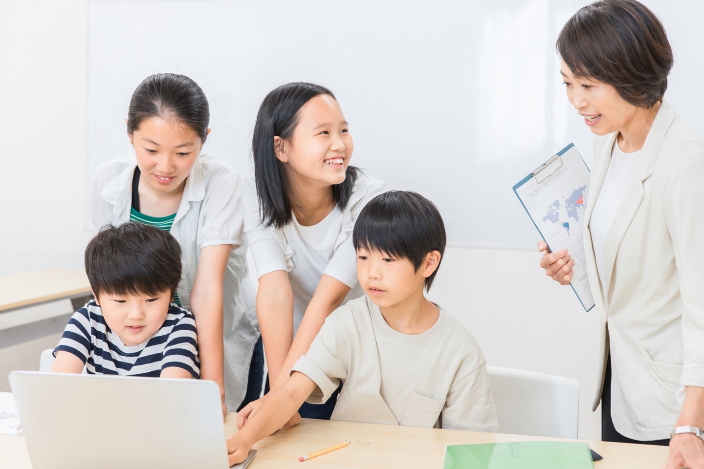 先生とパソコン学習に取り組む子どもたち