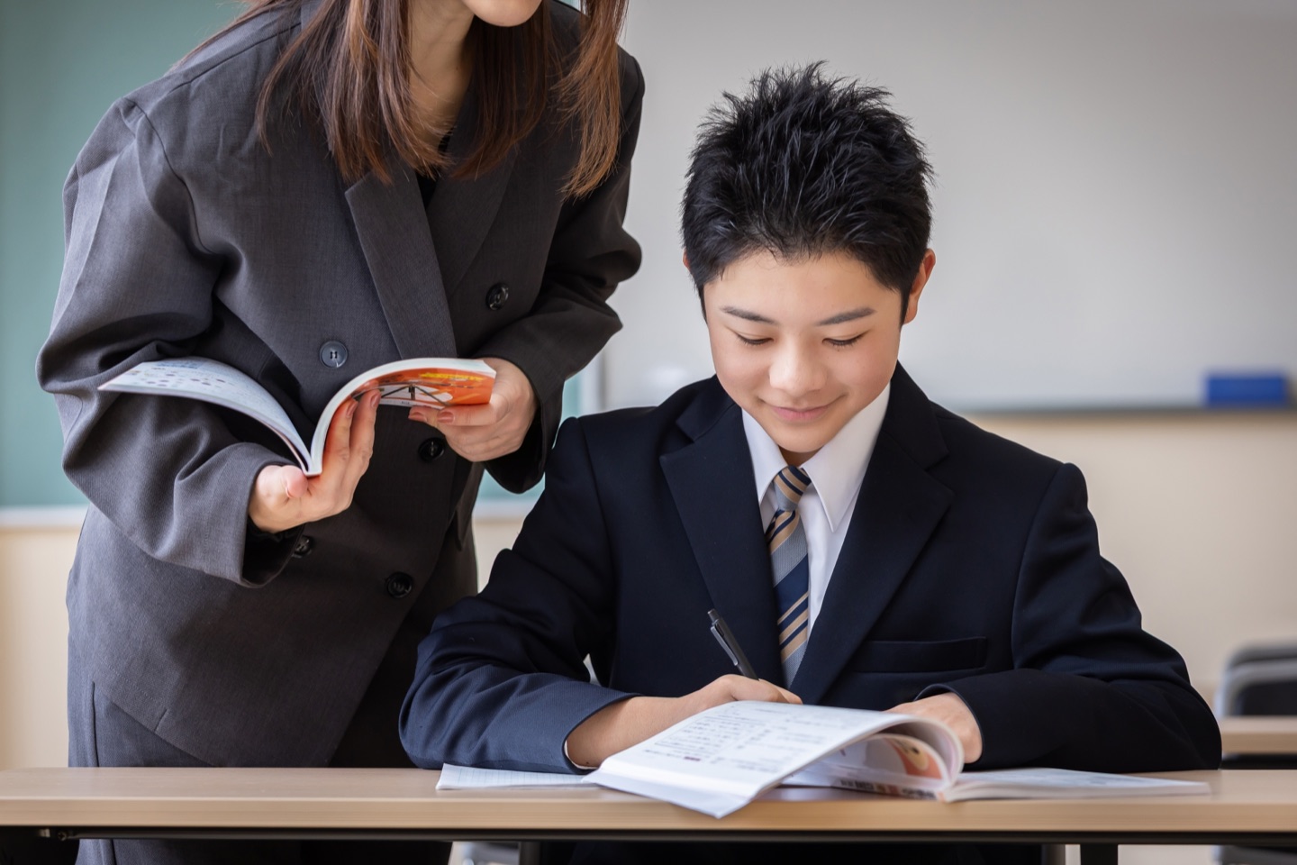 先生のサポートを受けて学習する中学生