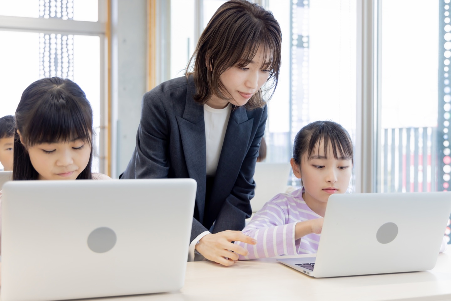 パソコンを使った学習を先生がサポートする様子