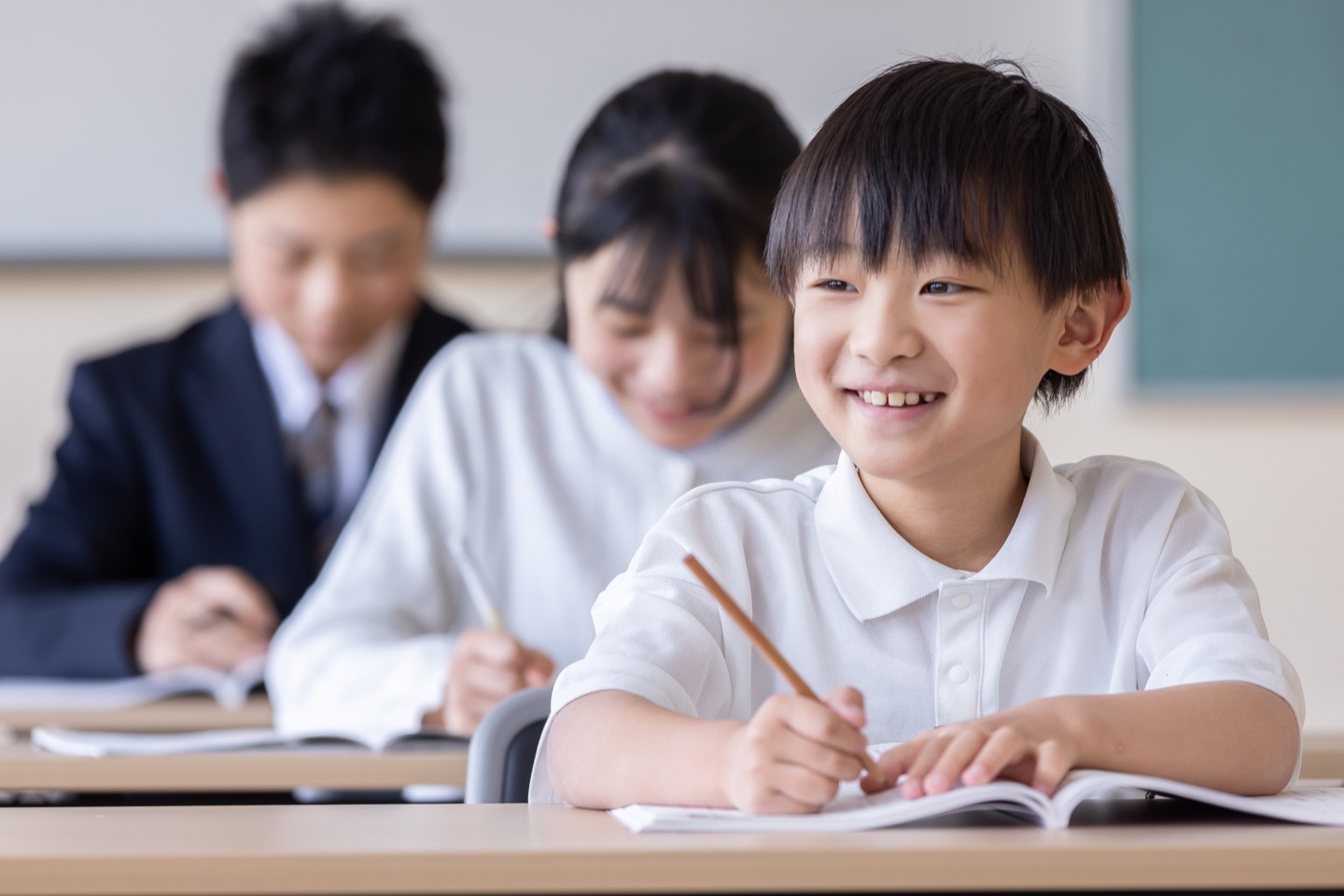 教室で笑顔で学ぶ小学生