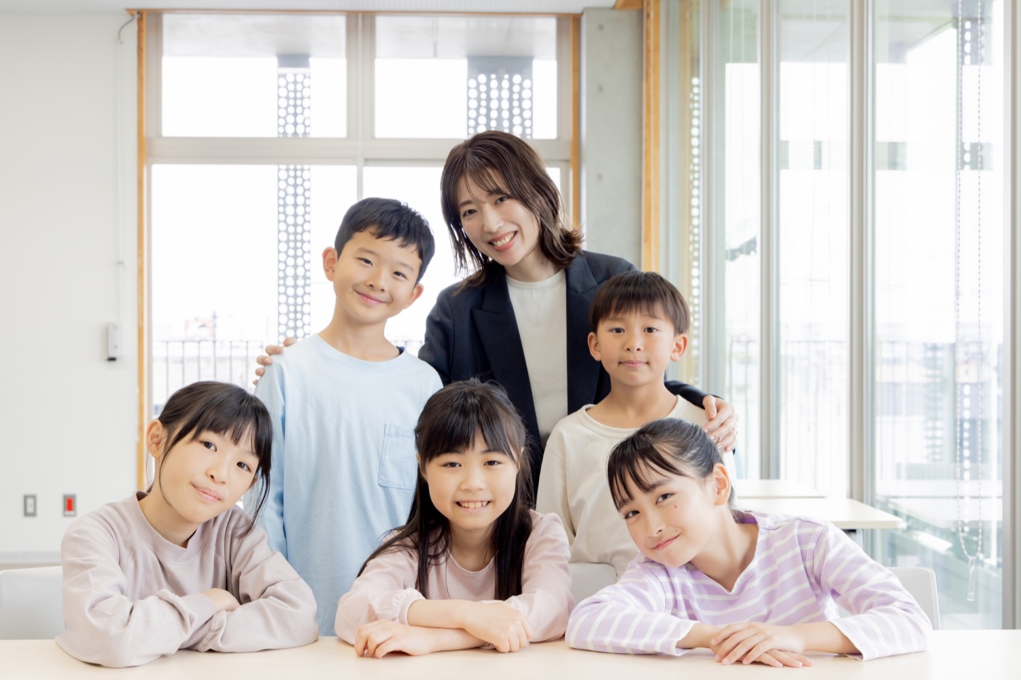 学びのイーアックの先生と笑顔で学ぶ小学生たち