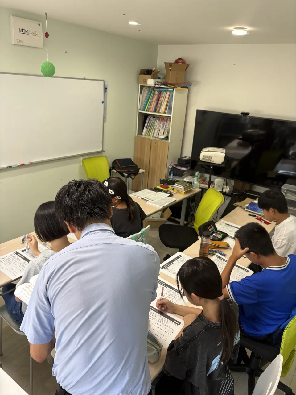 生徒のそばで授業を進める寺田先生の後ろ姿